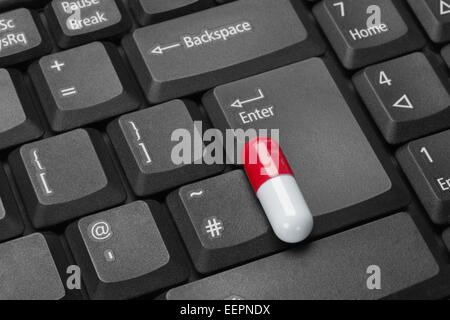Rote und weiße Kapsel auf schwarzen Computer-Tastatur Stockfoto