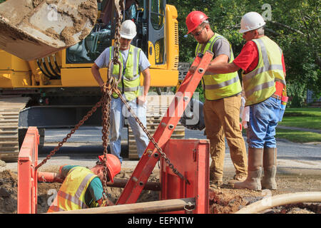 Bauarbeiter Loch mit Leiter hinunterklettern wird vorbereitet Stockfoto