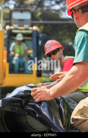 Platzieren Sie Bauarbeiter für Bagger heben Hauptwasserleitung in Vorbereitung Stockfoto