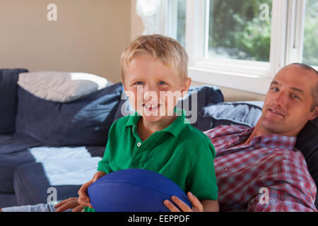 Vater und Sohn mit Hörschädigungen entspannen auf der couch Stockfoto