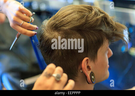 Stilvollen Mann mit einer Verletzung des Rückenmarks von einem Friseur einen Haarschnitt bekommen Stockfoto