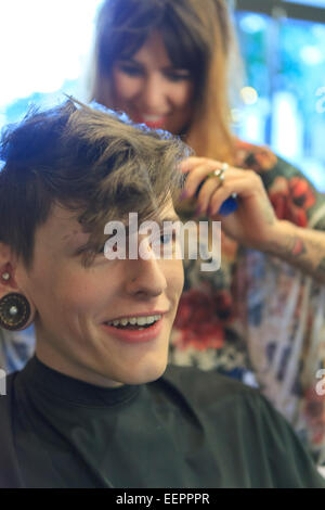 Stilvollen Mann mit einer Verletzung des Rückenmarks von einem Friseur einen Haarschnitt bekommen Stockfoto