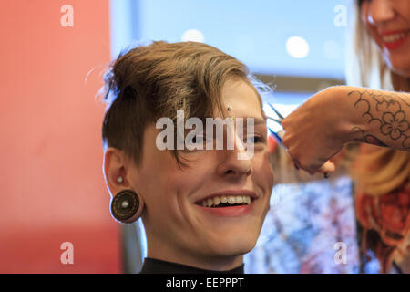 Stilvollen Mann mit einer Verletzung des Rückenmarks von einem Friseur einen Haarschnitt bekommen Stockfoto