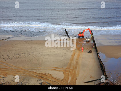 Die Bauarbeiten durchgeführt, bei Ebbe, einen Wellenbrecher bei Cromer, Norfolk, England, Vereinigtes Königreich zu reparieren. Stockfoto