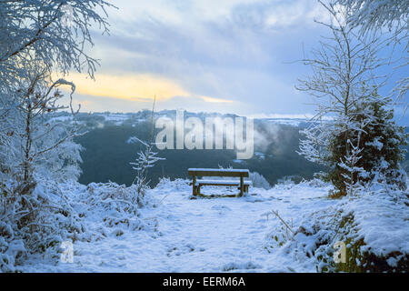 Holzbank mit Blick auf eine verschneite Wye Valley View. Stockfoto