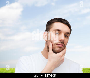 schöne ruhige Mann sein Gesicht berühren Stockfoto