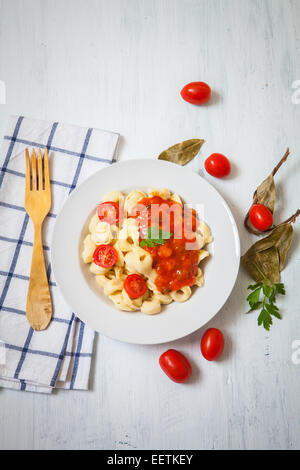 Tortellini mit Tomaten und Kräutern auf weißen Teller Stockfoto
