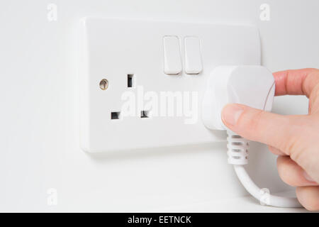 Hand, Stecker in die Steckdose Stockfoto