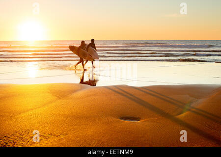 Zwei Surfer am Strand bei Sonnenuntergang laufen. Portugal ist eines der besten Surf-Szenen in Europ Stockfoto