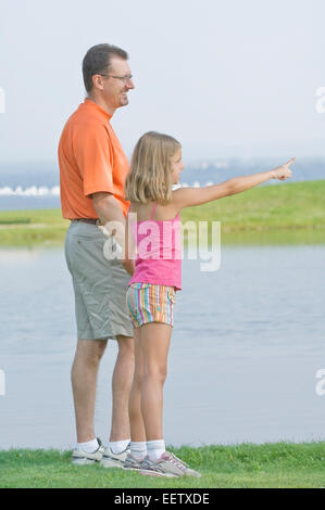 Vater und Tochter an einem See in einem Park zeigen Stockfoto