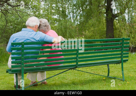 Älteres Paar auf Bank sitzend Stockfoto