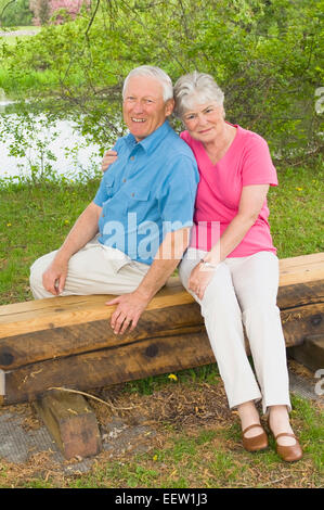 Älteres Paar auf Bank sitzend Stockfoto