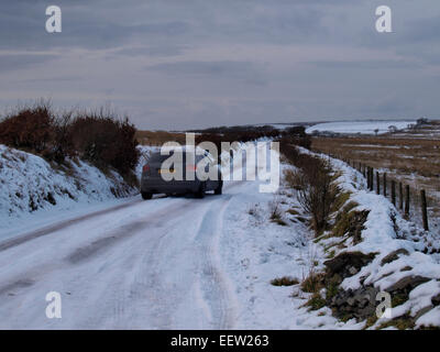 Auto auf einer Schnee bedeckten Straße, Exmoor, Somerset, Großbritannien Stockfoto