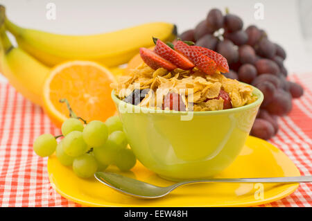 Schüssel mit Cornflakes mit Obst garniert Stockfoto