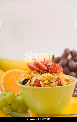 Schüssel mit Cornflakes mit Obst garniert Stockfoto