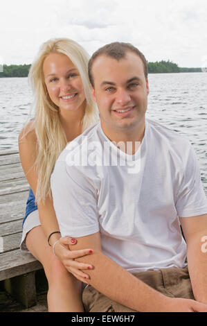 Ein paar sitzt auf einer Küstenlinie Stockfoto