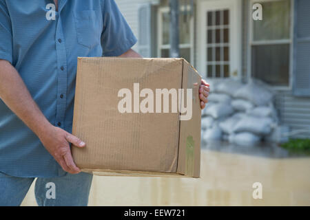 Mann mit Paket bei Hochwasser Stockfoto