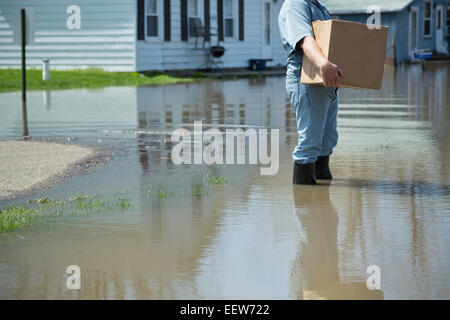 Mann mit Paket bei Hochwasser Stockfoto