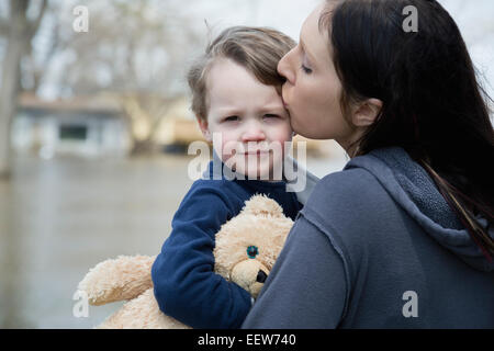 Mutter und Sohn stehen in der überfluteten Stadt Stockfoto