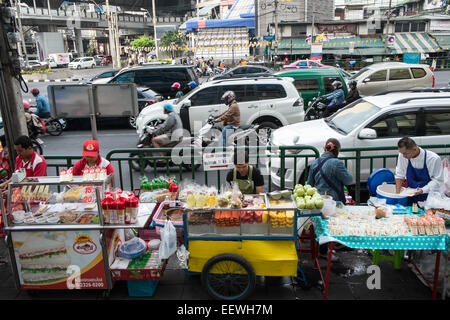 Roller warten an der Ampel an der Kreuzung der Asok und Sukhumvit. Verkehr, Verkäufer, Verkauf, Obst, Bangkok, Thailand, Asien. Stockfoto