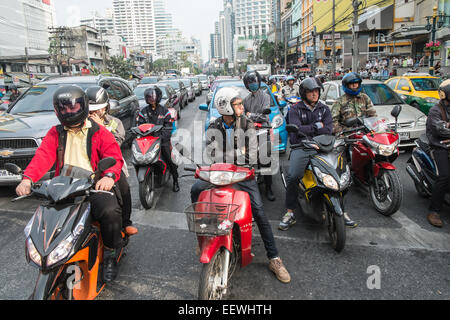 Roller warten an der Ampel an der Kreuzung der Asok und Sukhumvit. Verkehr, Autos, Roller, Sky Train, Bangkok, Thailand, Asien. Stockfoto