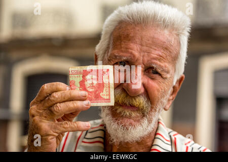 Älterer kubanischer Mann hält eine 3-Peso-Rechnung mit dem Porträt von Ernesto Che Guevara in der Hand, Havanna, Kuba Stockfoto