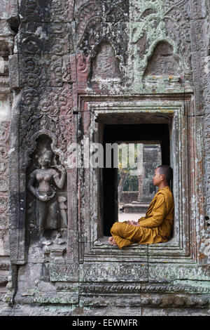 Junger Mönch Standortwahl in einem Fenster bei zerstörten Tempel Ta Prohm in Angkor Wat, Kambodscha Stockfoto