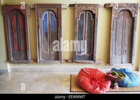 Vier alte traditionelle Bali Türen an einer Wand hängen. Stockfoto