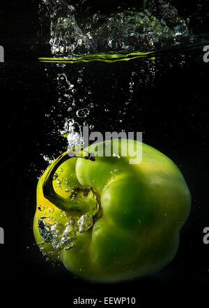 Eine grüne Paprika Spritzer ins Wasser Bläschen zu schaffen Stockfoto
