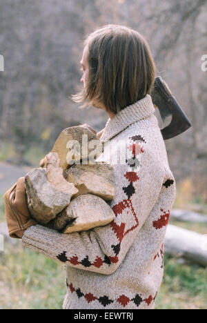 Junge blonde Mann mit Brennholz. Stockfoto