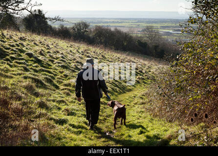 Mann zu Fuß Hund, Hellenge Hill in den Mendip Hills, Bleadon, Somerset England UK Stockfoto