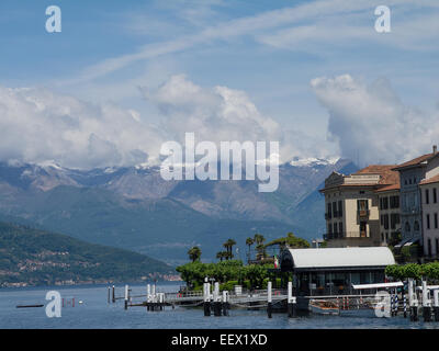 Blick auf den See mit kleinen Stegen und einer Kulisse schneebedeckter Berge, die von Bellagio am Comer See in Italien aus gesehen werden Stockfoto