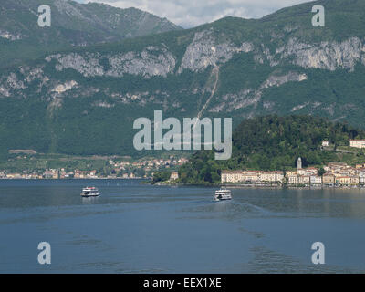 Bellagio von Cadenabbia am Comer See in Italien mit Fähren, die den See in jede Richtung überqueren und einer baumbestandenen Bergkulisse Stockfoto