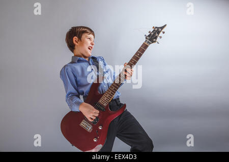 Teenager Boy braune Haare europäischen Aussehen spielt Gitarre, happ Stockfoto