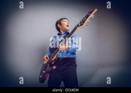 junge Jugend Europäischen Erscheinungsbild singt und spielt Gitarre Kreuz Stockfoto