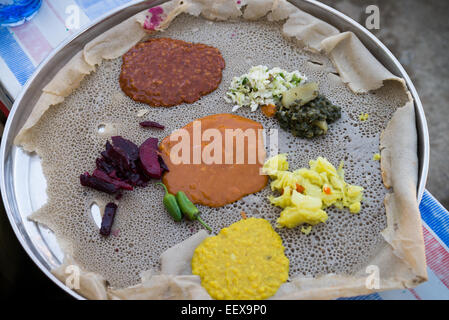 Traditionelle Äthiopische Küche, mehrere Arten von Saucen und Fleisch auf Injera serviert Stockfoto