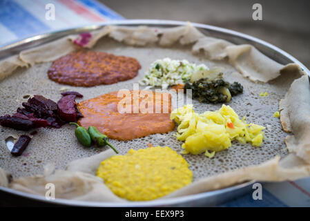Traditionelle Äthiopische Küche, mehrere Arten von Saucen und Fleisch auf Injera serviert Stockfoto