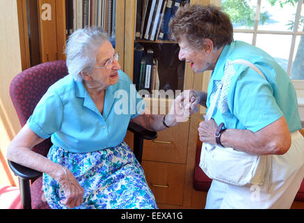 Guilford CT USA Edith Nettleton grüßt Doris Bedel, 92, während ihrem 105. Geburtstag in der Guilford Bibliothek, wo sie noch freiwillige. Bedel ist von Guilford. Stockfoto