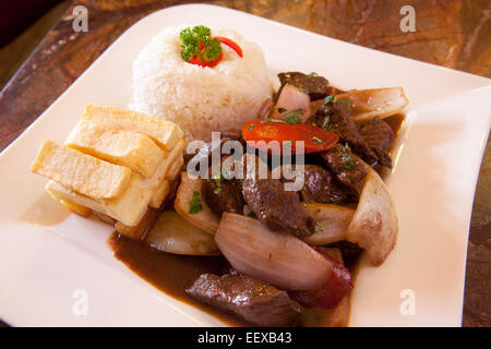 Peruanisches Essen "Lomo Saltado" (geschmortes Rindfleisch mit Tomaten) mit Reis. Cusco, Peru. Stockfoto