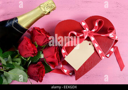 Happy Valentines Day rotes Herz Form Geschenkbox mit Flasche Champagner und rote Rosen Stockfoto