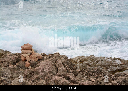 Türkis Wave spritzt auf wenig Stein Turm und Ufer am Cap de Ses Salines. Stockfoto