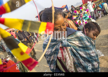 Morigaon, Assam, Indien. 23. Januar 2015. Eine Indianerin mit ihrem Kind aus der Tiwa Gemeinschaft während den Austausch von waren durch Tauschsystem beim Joonbeel Festival in Morigaon Bezirk von Northeasterb Assam Zustand am 23. Januar 2014 zu sehen. Hunderte von Stammes-Gemeinschaften wie Tiwa, Karb, Khasi und Jaintia vom nahe gelegenen Hügel kommen in großer Zahl zur Teilnahme an Festivals Austausch waren durch Tauschhandel, anstatt Geld. Gemeinschaft Angeln ist auch während des Festivals statt. Der wesentliche Punkt des Festivals ist das Thema der Harmonie und der Brüderlichkeit unter den verschiedenen Stämmen und Kommunikation Stockfoto