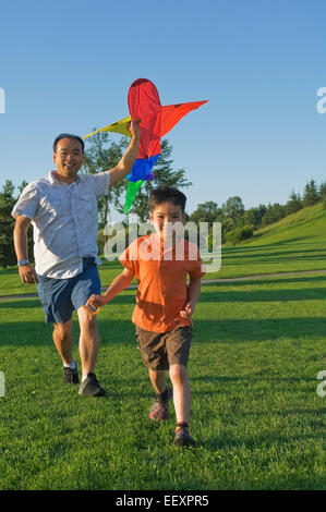 Vater und Sohn im Park mit einem Drachen Stockfoto