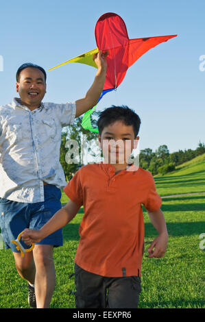 Vater und Sohn im Park mit einem Drachen Stockfoto