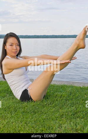 Frau beim Yoga am See Stockfoto