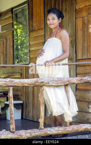 Schwangere Frau stand auf der veranda Stockfoto