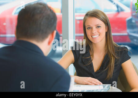 Frau im Büro im Autohaus Stockfoto
