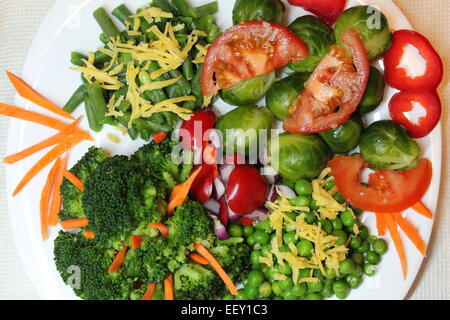 appetitlich frische bunte Vegetarische Teller voll saftigen Gemüse Rosenkohl, Karotte, Zwiebel, Erbsen, Tomaten, Paprika, Brokkoli Stockfoto