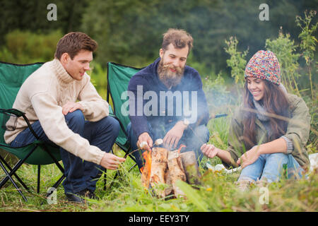 Gruppe von lächelnden Freunde Lagerfeuer sitzen Stockfoto