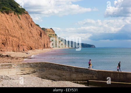 Rote Klippen bei Sidmouth, East Devon, England, UK - mit der Familie zu Fuß entlang einer steinernen Steg im Sommer Stockfoto